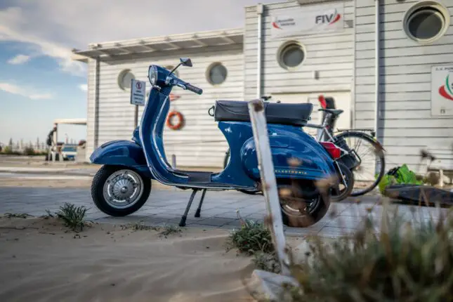 a blue scooter parked next to a building