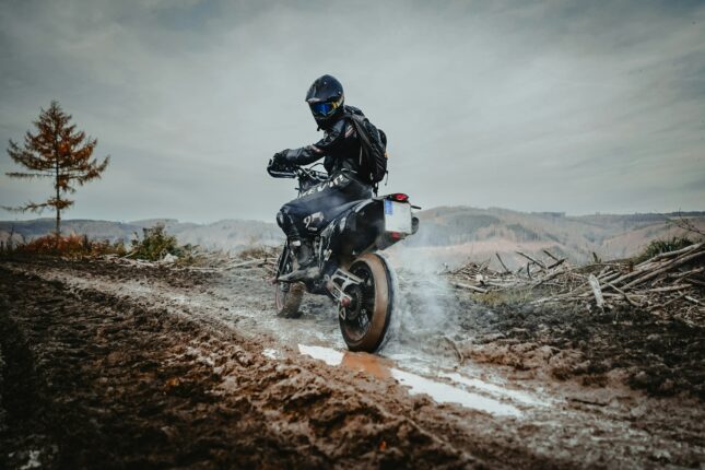a person riding a motorcycle on a muddy road