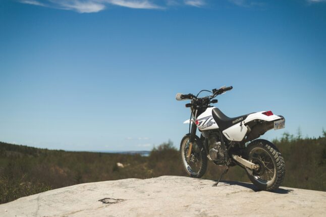 white and black motorcycle on brown sand under blue sky during daytime