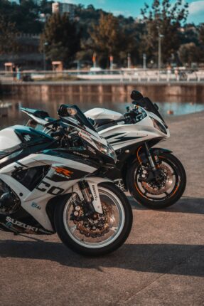 white and black sports bike parked on gray concrete road during daytime